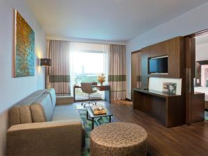 a living room with a couch and a tv at Novotel Chennai Sipcot in Chennai