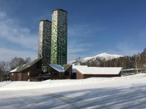 a building with two tall buildings in the snow at Santari in Shintoku