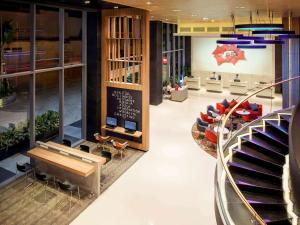 a lobby of a building with a staircase and chairs at Ibis Saigon Airport in Ho Chi Minh City