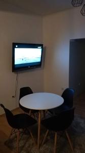 a room with a table and chairs and a tv at Przy Leśnej in Szklarska Poręba