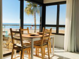 stół jadalny i krzesła z widokiem na ocean w obiekcie Victoria Beach Sunset Lounge w Kadyksie