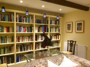 une chambre avec de nombreuses étagères remplies de livres dans l'établissement The Coach House, à Austwick