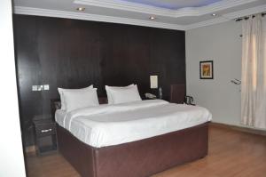 Rúm í herbergi á Triple Tee Hotel