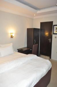 Rúm í herbergi á Triple Tee Hotel