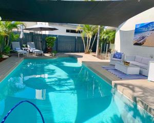 a swimming pool with blue water in a backyard at Mermaid Beach House in Gold Coast