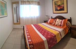 1 dormitorio con 1 cama con una manta colorida en Famiglia Dtos en San Rafael