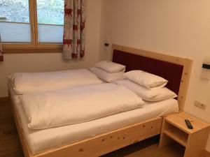 a bedroom with two beds with white sheets and a window at Chalet Glemmtal - Haus Bergblick in Viehhofen