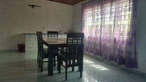 een tafel en stoelen in een keuken met een raam bij D'Villa KP in Kuala Terengganu