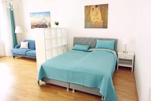 Schlafzimmer mit einem Bett mit blauer Decke in der Unterkunft Herzlich Willkommen - Küss die Hand in Wien