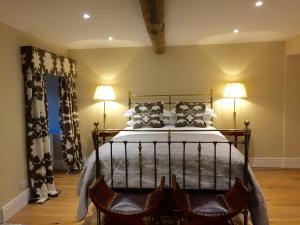 Austwick的住宿－The Coach House，一间卧室配有一张带两盏灯和两把椅子的床。