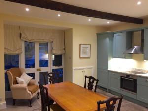 a kitchen with a wooden table and a dining room at The Coach House in Austwick