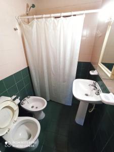 Un baño con dos inodoros, un lavabo y una ducha. en Mis Casitas, en Chajarí