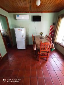 Un comedor con una mesa y un refrigerador. en Mis Casitas, en Chajarí