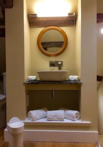 La salle de bains est pourvue d'un lavabo et d'un miroir. dans l'établissement The Coach House, à Austwick