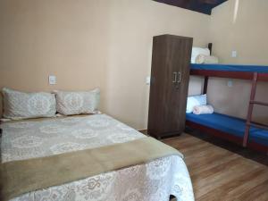 a bedroom with a bed and two bunk beds at Acomodação chalé entre capitolio e escarpas do lago in Capitólio