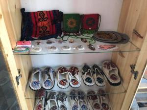 a shelf filled with lots of shoes and plates at Guest House EtnoDom in Jalal-Abad