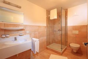 uma casa de banho com um lavatório, um WC e um chuveiro em Residenz Scherrhof em Kirchberg in Tirol