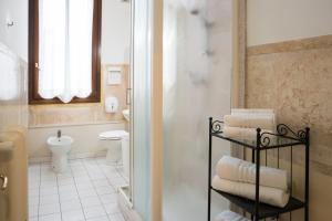 a bathroom with a toilet and a shower with towels at Corte Canal Venice in Venice