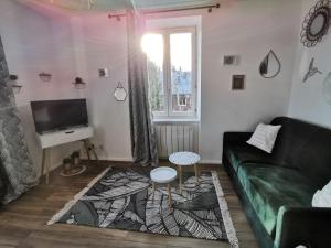 uma sala de estar com um sofá verde e uma mesa em Au Coeur des Rousses em Les Rousses