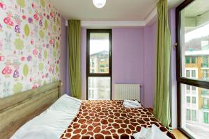 a bedroom with purple walls and a bed with a window at Apart 516 Bobline in Bakuriani