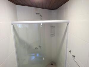 a shower with a glass door in a bathroom at Pousada Nusa Dua Maresias in Maresias