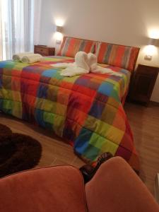 ein Bett in Regenbogenfarbe mit ausgestopftem Tier drauf in der Unterkunft B&B Belli Dentro in Verona