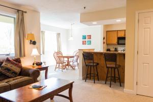 sala de estar y cocina con sofá y mesa en Vantage Point Villas at Stratton Mountain Resort, en Stratton Mountain