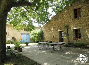 a patio with tables and chairs in front of a brick building at La Mare Chambres d'Hôtes Chaix accueil in Étoile-sur-Rhône