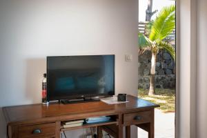 a flat screen tv sitting on top of a wooden table at T2A Lagon Austral "Jardin du lagon" in Saint-Pierre