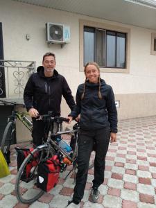 a man and a woman standing next to a bike at Guest House EtnoDom in Jalal-Abad