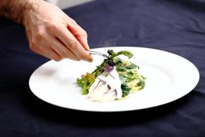 a person eating a salad on a white plate at Hotel Du Soleil in Rimini