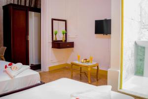 Cette chambre comprend 2 lits, une table et un miroir. dans l'établissement Golden Palace Hotel, au Caire