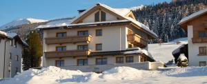 a house in the snow with snow around it at Hotel Garni Regina in Weerberg