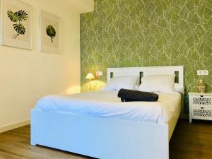 1 dormitorio con cama blanca y cabecero blanco en Apartamento Ecuador, en Cádiz