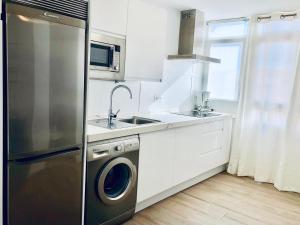 cocina con nevera de acero inoxidable y fregadero en Apartamento Ecuador, en Cádiz