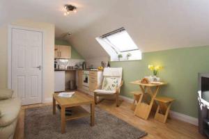 a living room with a table and a kitchen at Nolton Haven Farmhouse Apartment, Sea Views in Haverfordwest