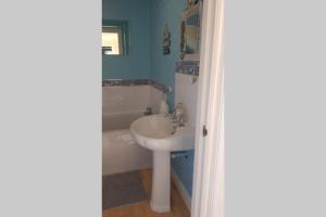 a bathroom with a sink and a tub at Nolton Haven Farmhouse Apartment, Sea Views in Haverfordwest