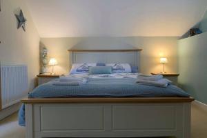 a bedroom with a large bed with two lamps at Nolton Haven Farmhouse Apartment, Sea Views in Haverfordwest