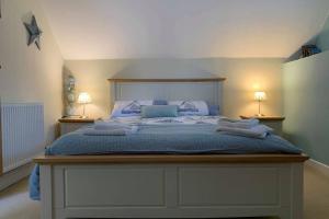 een slaapkamer met een groot bed met twee lampen bij Nolton Haven Farmhouse Apartment, Sea Views in Haverfordwest