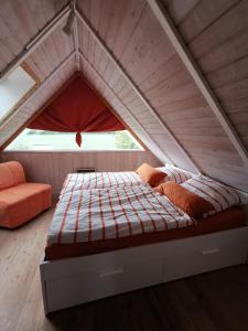 a bed in the middle of a room in a attic at Ferienhaus mit eigenem Garten, 200m zum Strand, Gartensauna gegen Gebühr zubuchbar in Neukirchen