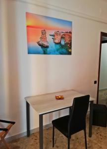 a table with a chair and a painting on the wall at Rosita Rooms in Lecce +22 photos