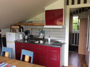a kitchen with red cabinets and a sink at Hemmet Brommösund Torsö Mariestad in Brommösund