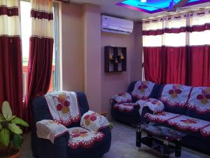 布萊爾港的住宿－Abhi's homestay，客厅配有两张沙发和红色窗帘