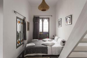 Riad Dar-tus في طنجة: غرفة نوم بسرير ذو شراشف ووسائد بيضاء