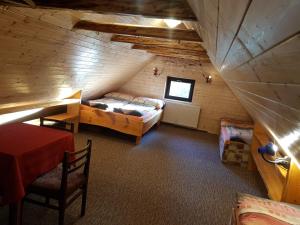 a attic room with a bed and a table and chairs at Apartments V Zatáčce in Albrechtice v Jizerských horách
