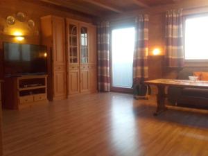 a living room with a television and a wooden floor at Haus Melanie in Hohenau