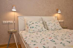 a bedroom with a white bed with flowers on it at Pärnu Apartment in Pärnu