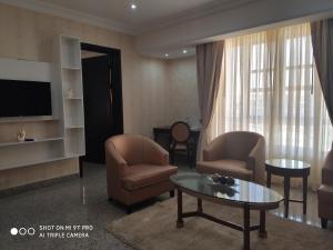 a living room with chairs and a tv and a table at Conference Hotel , Abeokuta in Abeokuta