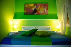 PellaroにあるB&B Arcobalenoの緑のベッドルーム(緑の枕2つ付きのベッド1台付)