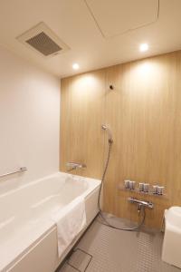 La salle de bains est pourvue d'une baignoire et de toilettes. dans l'établissement Henn na Hotel Kanazawa Korimbo, à Kanazawa